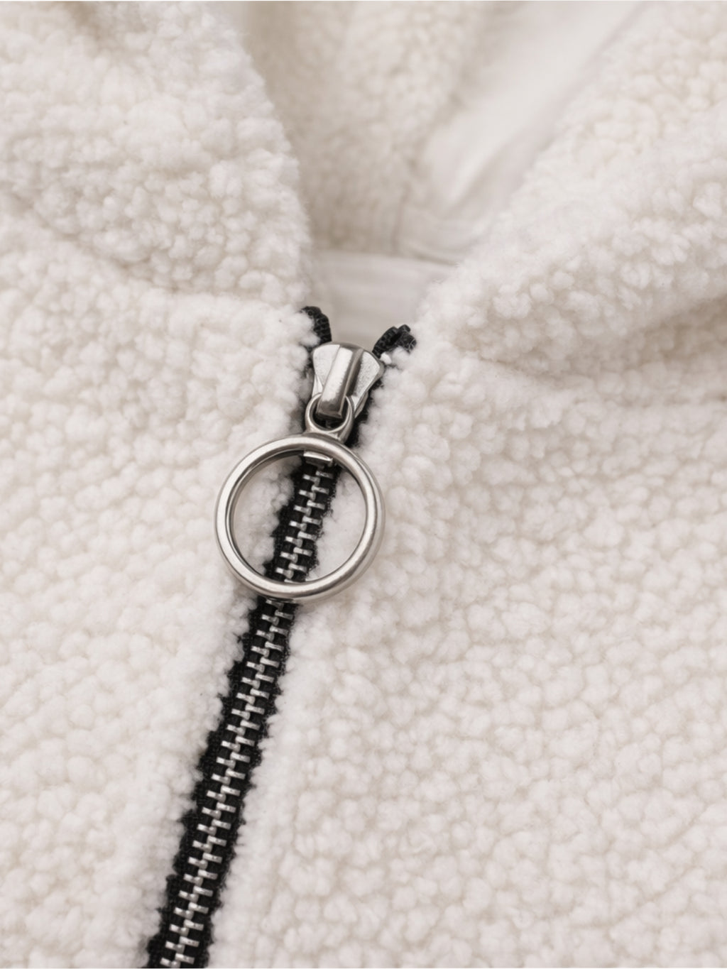 Close-up of a zipper on a textured white fabric background