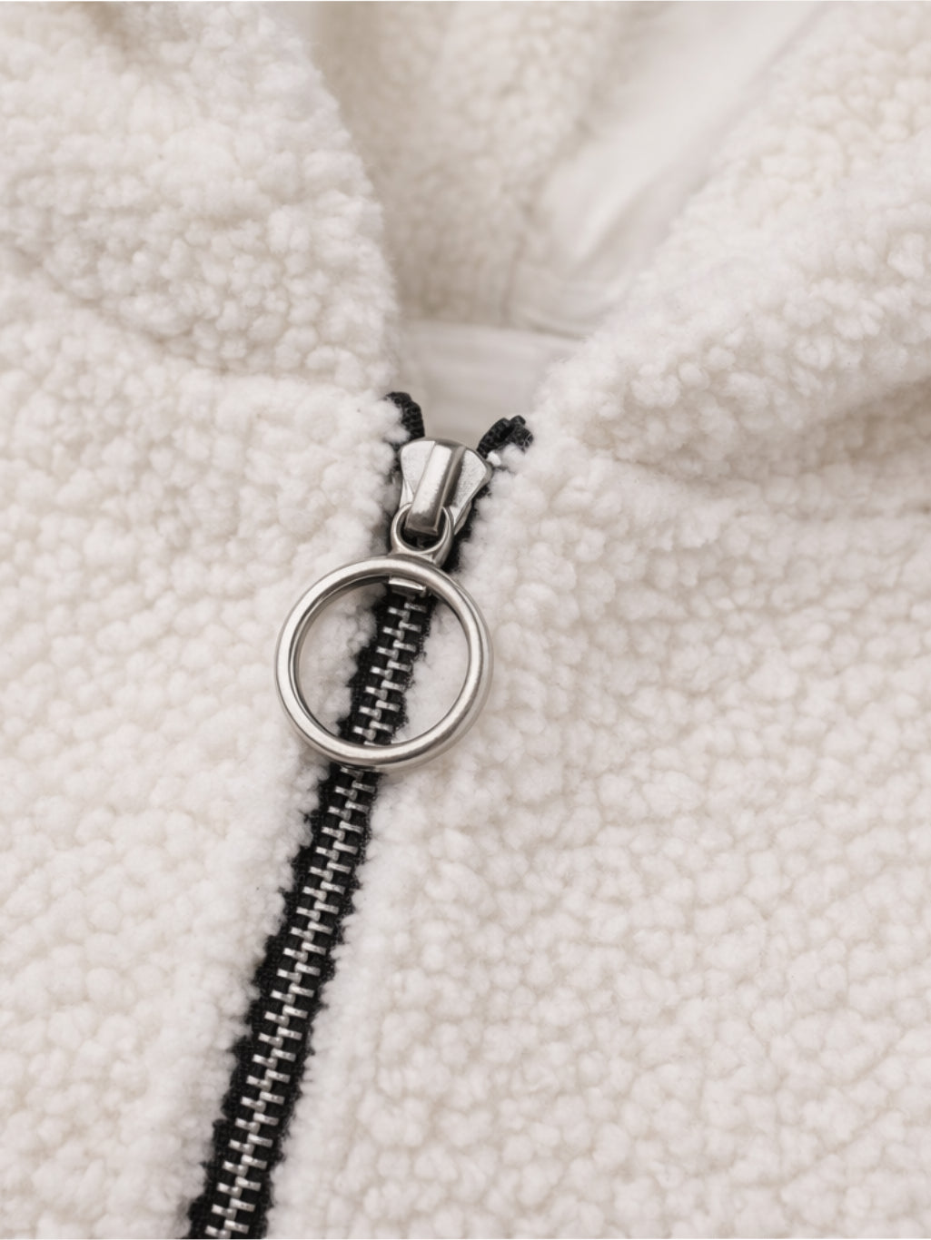 Close-up of a zipper on a textured white fabric background